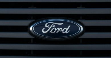 Detailed view of a Ford emblem mounted on a vehicle grille, showcasing modern design.