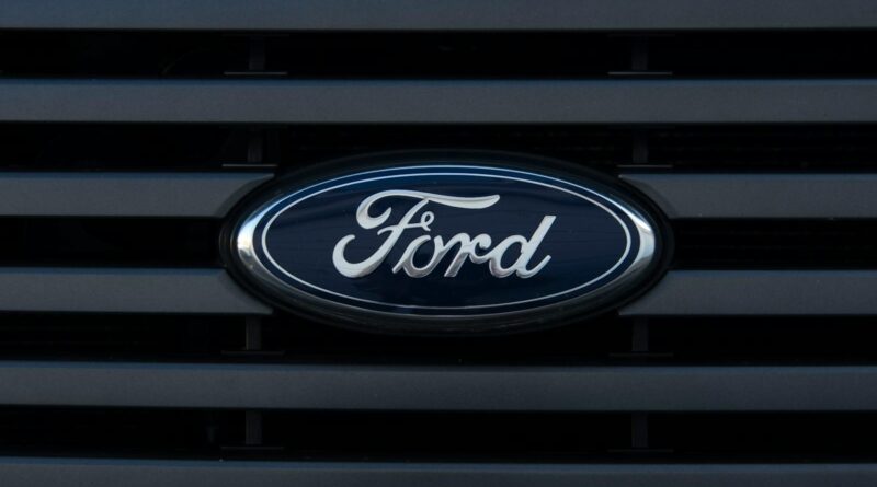 Detailed view of a Ford emblem mounted on a vehicle grille, showcasing modern design.