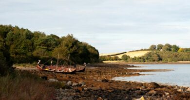 a boat sitting on top of a rocky shore