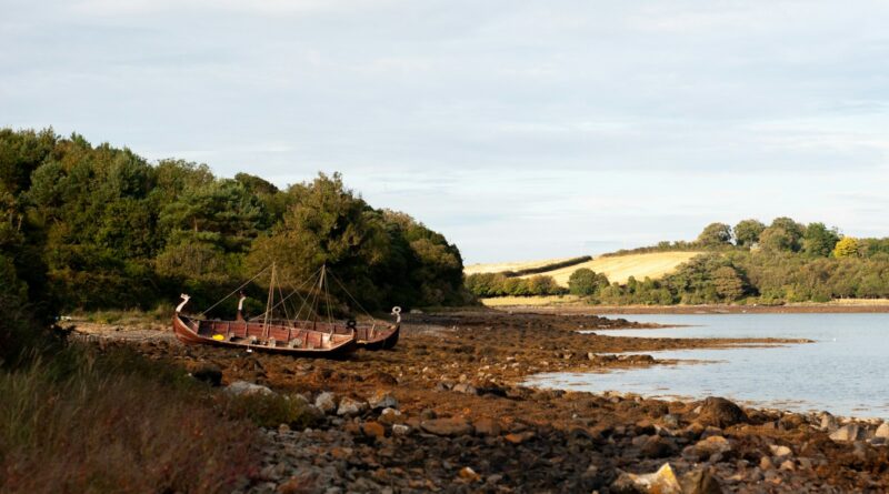 a boat sitting on top of a rocky shore